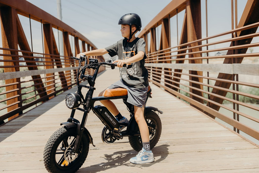Electric bicycle with kid, featuring a sleek frame, battery pack, and pedal-assist motor.